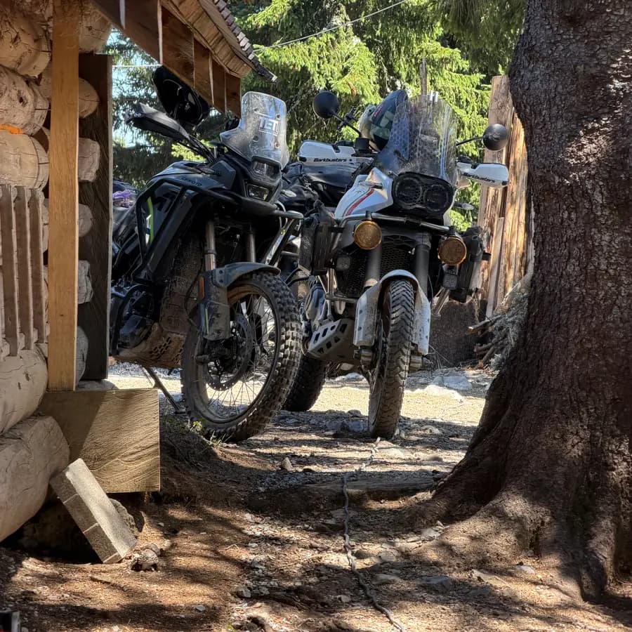 Adventure bikes parked at a wooden mountain hut