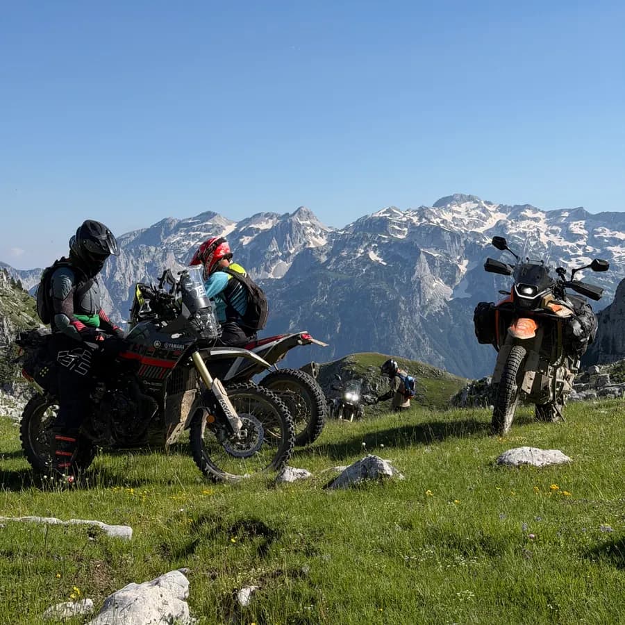 Riders below snow-streaked Balkan peaks