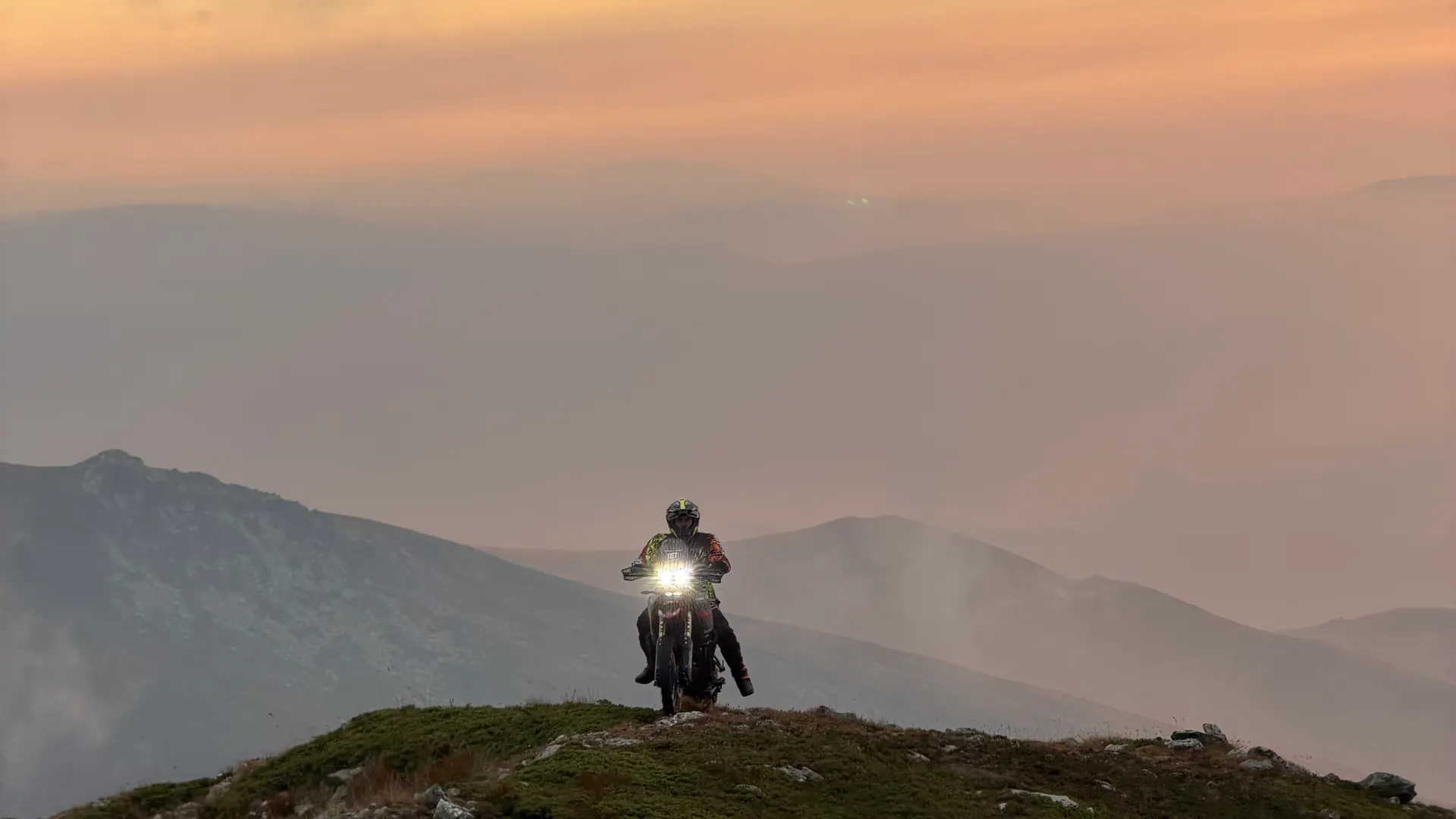 Lone rider on a ridge crest above a sea of cloud at dusk