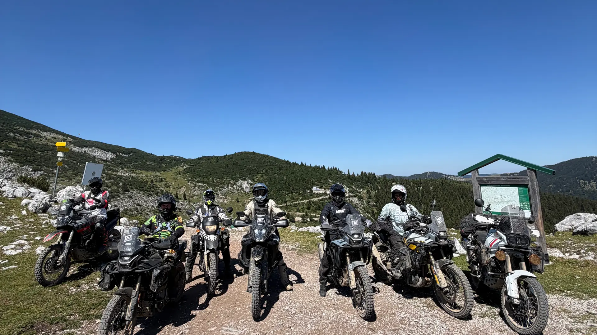 Six riders lined up on their adventure bikes on a Kosovo mountain ridge